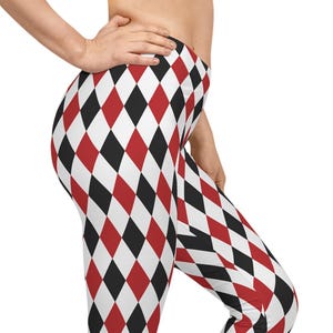 May include: Full-length leggings featuring a repeating harlequin diamond pattern in alternating colors of red, black, and white. The fitted garment extends from the waist to the ankles, showcasing a consistent geometric print across the entire fabric.