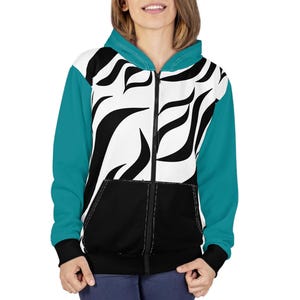 May include: A zip-up hoodie featuring a white front panel with a black abstract flame-like pattern, solid teal sleeves, a teal hood, and a solid black lower front pocket section. The garment has a full-length black zipper and black sleeve cuffs.