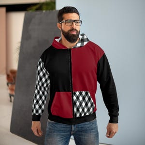 May include: A zip-up hoodie featuring a color-blocked design with a solid black left side, a solid dark red right side, and a black and white checkered pattern on the right sleeve and lower right pocket. The hood interior also features a checkered pattern.