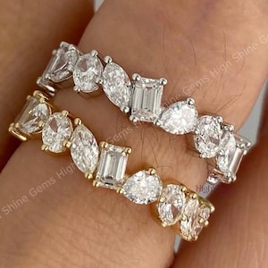 Puede incluir: Dos anillos con piedras preciosas transparentes de varias formas, incluyendo óvalos, peras y cortes esmeralda. Un anillo es dorado y el otro plateado. Los anillos están engastados con múltiples piedras preciosas. El texto "High Shine Gems High Shine Gems High Shine Gems" es visible.