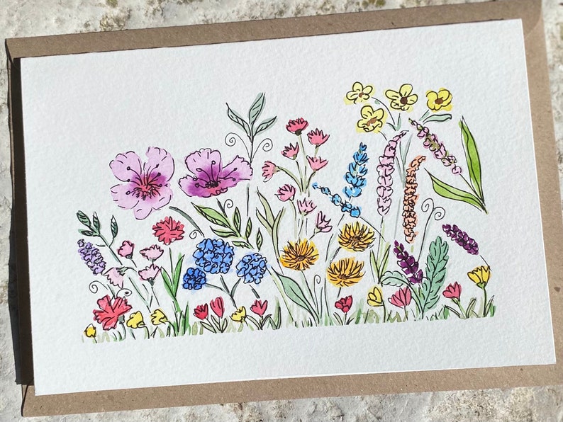 May include: Watercolor painting of a field of flowers in various colors, including pink, purple, blue, yellow, and red. The flowers are drawn in a simple, whimsical style.