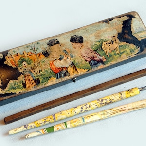 Plumier vintage "illustré" en carton bouilli + 2 porte-plumes anciens (avec plumes)+Petite règle écolier en bois.