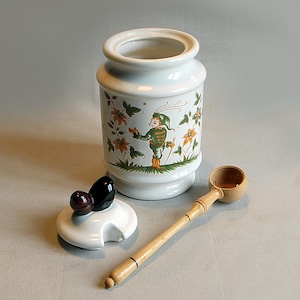 White ceramic olive pot with green and orange pattern.