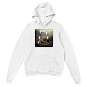 Könnte beinhalten: Ein weißer Kapuzenpullover mit langen Ärmeln und einem quadratischen Grafikdruck auf der Brust. Der Druck zeigt eine Landschaftsansicht einer Stadt in einem Tal, umgeben von Bergen unter einem dunstigen Himmel. Der Hoodie hat eine Kängurutasche.