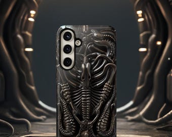 May include: Black phone case with a detailed graphic of an alien creature. The case has a raised camera bump with three lenses.