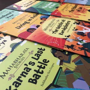 May include: A stack of colorful children's books with illustrations and titles related to the Mahabharata, an epic Hindu poem. The titles include "Karna's Last Battle", "The Battle at Kurukshetra", "Living in Exile", "The Game of Dice", and "The Palace of Lac".