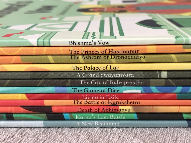May include: A stack of colorful books with titles related to the Indian epic, the Mahabharata. The titles include "Bhishma's Vow", "The Princes of Hastinapur", "The Ashram of Dronacharya", "The Palace of Lac", "A Grand Swayamvara", "The City of Indraprastha", "The Game of Dice", "Living in Exile", "The Battle at Kurukshetra", "Death of Abhimanyu", "Karna's Last Battle", and "A New Beginning".