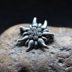 エーデルワイスの高山の花のジュエリー シルバー ブローチ ブローチ。シルバーピンのエーデルワイスの花。岩の銀色の花。アルパインスターピンエーデルワイスの花