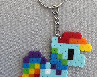 May include: A rainbow-colored beaded keychain shaped like a unicorn. The unicorn is light blue with a rainbow mane and tail. The keychain is attached to a silver key ring.