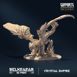 May include: A 3D printed miniature of a crystal dragon with wings spread, standing on a base with crystal formations. The dragon is beige and has a detailed, textured surface. The text "SUPPORTS INCLUDED" is visible in the upper right corner of the image.