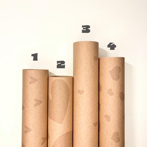 Vier nummerierte Kraftpapier-Geschenkpapierrollen mit dezenten Herz-Designs zur Auswahl – Design 1 kleine Herzen, Design 2 abstrakt, Design 3 mittlere Herzen, Design 4 große Herzen in Ton-in-Ton Brauntönen, natürliches Geschenkpapier für Jahrestag und Geburtstag