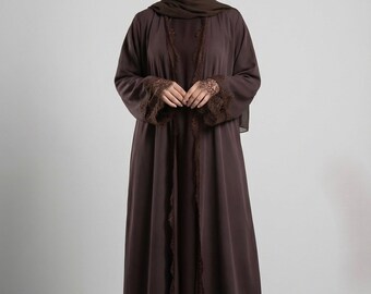 May include: A dark brown abaya and matching hijab. The abaya features lace detailing on the sleeves and along the front edges. The outfit is a modest, elegant style, suitable for formal occasions.