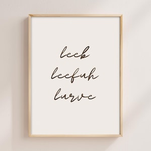 May include: A framed print with the words "Leek, Leefuh, Lurve" written in cursive script on a white background.