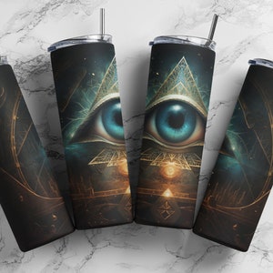 Puede incluir: Conjunto de cuatro vasos de acero inoxidable con un diseño negro y dorado que presenta un ojo que todo lo ve dentro de un triángulo. El ojo es azul y el triángulo está delineado en oro.