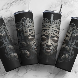 Puede incluir: Cuatro vasos de acero inoxidable con fondo negro y un diseño plateado detallado de una cara con intrincados patrones. Los vasos están dispuestos en círculo sobre una superficie de mármol blanco.