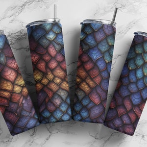 Peut inclure: Quatre gobelets en acier inoxydable avec un motif d'écailles de dragon coloré. Les gobelets sont disposés en éventail avec les pailles qui dépassent.