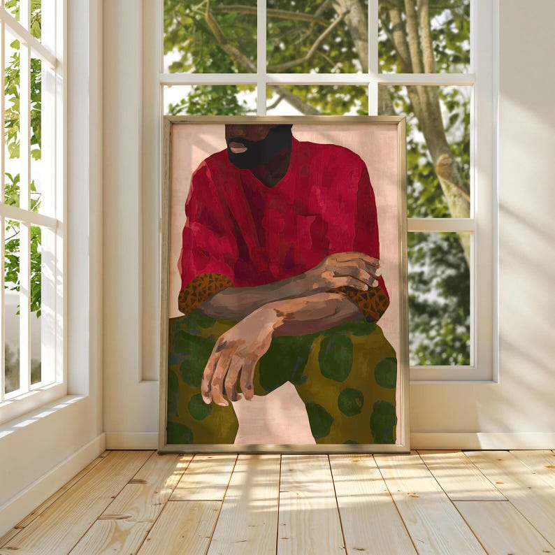 Puede incluir: Impresi&oacute;n art&iacute;stica enmarcada que representa una figura sentada con una camisa roja y pantalones verdes estampados. La obra de arte tiene una paleta de colores c&aacute;lidos, con los brazos cruzados. El fondo es rosa p&aacute;lido.