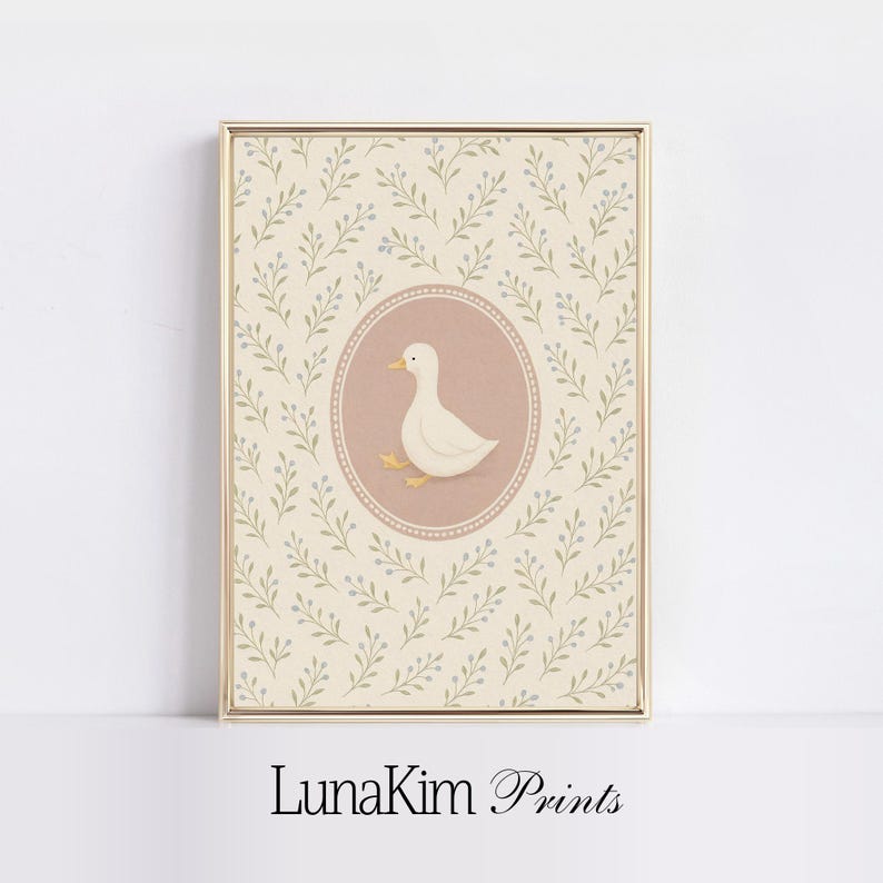 Puede incluir: Un pato blanco con un pico rosa y patas amarillas se representa en un c&iacute;rculo rosa sobre un fondo crema con un patr&oacute;n floral verde claro y morado. El texto "LunaKim Prints" est&aacute; en la parte inferior de la imagen.
