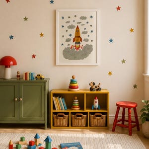 May include: A framed wall print featuring a rocket ship launching amidst gray clouds and blue stars, surrounded by colorful star wall decals. The room includes a yellow storage unit, a green cabinet, a red stool, and various wooden toys.