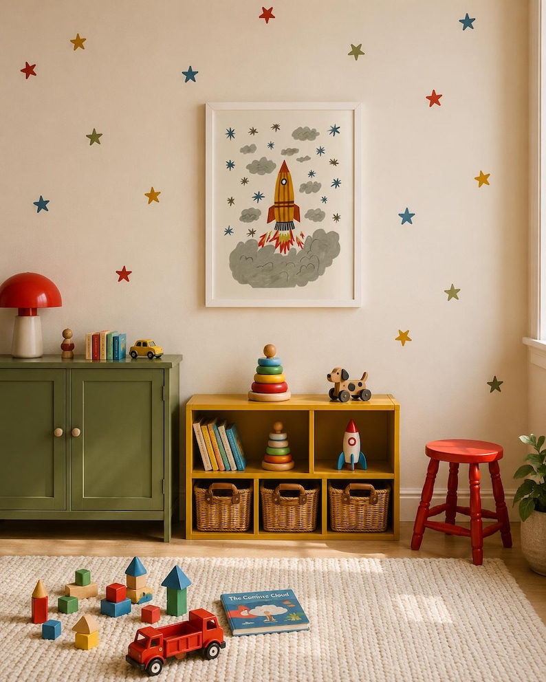 May include: A framed wall print featuring a rocket ship launching amidst gray clouds and blue stars, surrounded by colorful star wall decals. The room includes a yellow storage unit, a green cabinet, a red stool, and various wooden toys.