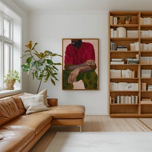 Puede incluir: Una toma interior de un sal&oacute;n moderno con una gran pintura como punto focal. La pintura representa a una persona con una camisa roja y pantalones verdes estampados. Tambi&eacute;n se ven un sof&aacute; seccional de cuero marr&oacute;n, una estanter&iacute;a de madera y una ventana grande.