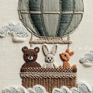 May include: Embroidered artwork featuring a hot air balloon with a basket holding a brown teddy bear, a white bunny, and an orange deer. The balloon is green and gray, with white clouds surrounding the basket.