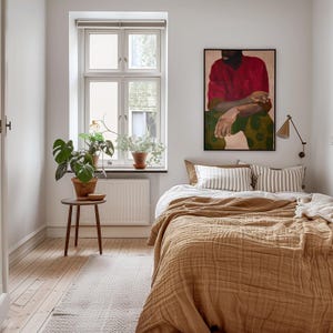 Puede incluir: Un dormitorio con una cama cubierta con una manta marr&oacute;n texturizada y almohadas a rayas. Una pintura enmarcada cuelga sobre la cama. Una peque&ntilde;a mesa de madera sostiene una planta en maceta. Una ventana con plantas est&aacute; a la izquierda.