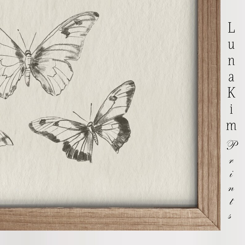 Puede incluir: Una impresi&oacute;n enmarcada con fondo blanco que presenta un dibujo en blanco y negro de tres mariposas. El texto "Luna Kim Prints" est&aacute; en la esquina inferior derecha del marco.