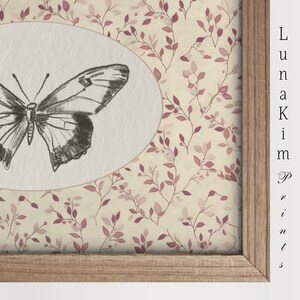 May include: A framed print with a delicate butterfly illustration in a white oval on a background of pink and cream floral pattern.