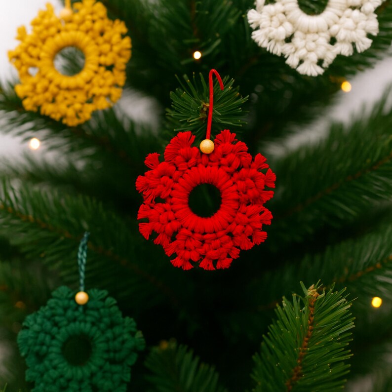 Macrame snowflake ornaments hanging on a Christmas tree, showing how the handmade designs can be used as festive holiday and winter decorations.