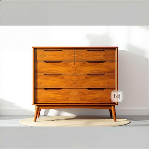 A handcrafted mid-century modern teak wood dresser with spacious drawers, featuring elegant curved drawer fronts and tapered legs. The dresser is made from solid natural teak with rich warm grains, placed in a bright minimalist room with white walls, soft natural light, a framed abstract artwork, two ceramic vases, and a textured white rug on light wood flooring. Modern, Scandinavian, and Japandi-inspired wooden furniture for premium home interiors.