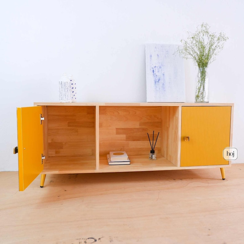 Yellow fluted media console with solid wood body and gold metal legs in modern living room