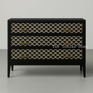 Könnte beinhalten: Schwarze Kommode mit drei Schubladen, die ein goldenes geometrisches Muster aufweisen. Jede Schublade hat einen goldenen Griff.