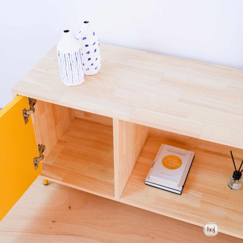Aura yellow media console with fluted doors, gold knobs, and open shelf storage