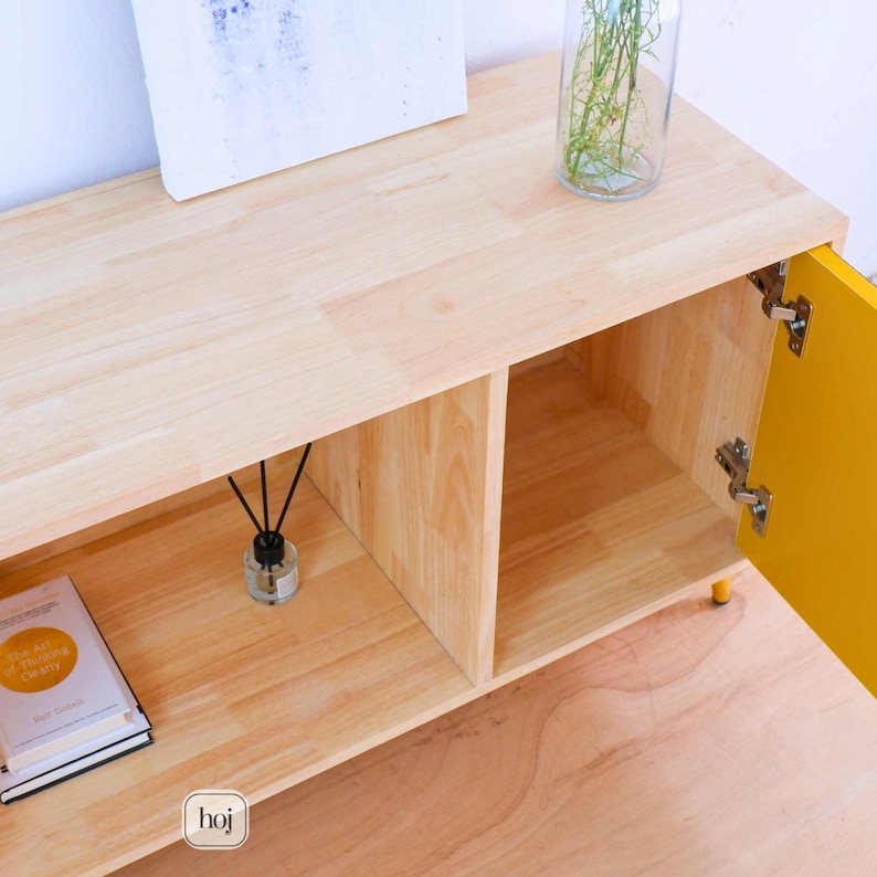 Aura yellow media console with fluted doors, gold knobs, and open shelf storage