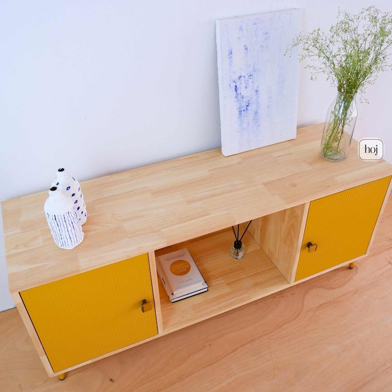 Yellow fluted media console with solid wood body and gold metal legs in modern living room