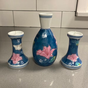 Small Arita Japanese blue and white vase with pink, white, green and yellow florals,  and matching candle holders- all signed by designer