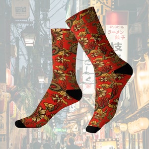May include: A pair of red socks with a detailed golden dragon and floral pattern. The socks have black heels and toes. The design features dragons, flowers, and clouds, creating a vibrant and ornate look.