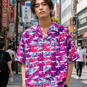 May include: A short-sleeved button-down shirt with a vibrant pattern of koi fish and floral designs in shades of pink, purple, and blue. The shirt is worn by a person standing on a city street.