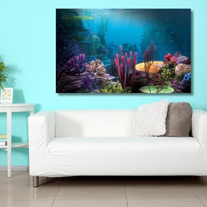 May include: A rectangular wall art print featuring a vibrant underwater coral reef scene with deep blue water, purple sea fans, bright pink tube sponges, and various colorful coral formations displayed above a white sofa in a room.
