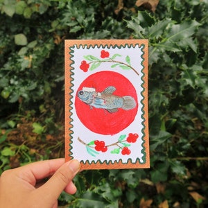 Postal navideña original pintada a mano y hecha a mano con pintura de peces y bayas