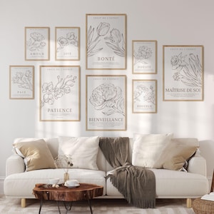 Pode incluir: Um conjunto de nove impressões emolduradas com ilustrações florais e texto em francês. Cada impressão apresenta uma flor diferente e a palavra "Fruit de l'Esprit" (Fruto do Espírito) no topo. As impressões estão dispostas em uma grade em uma parede branca.