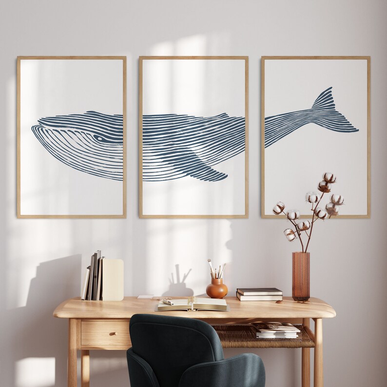 May include: Three framed prints of a blue whale illustration. The whale is depicted in a line art style with a white background. The prints are arranged in a row on a white wall.