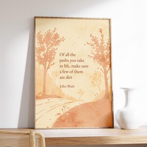 May include: A printable art print with a quote by John Muir: "Of all the paths you take in life, make sure a few of them are dirt." The quote is set against a watercolor background of a path winding through a forest.