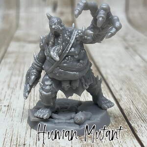 May include: A gray 3D printed miniature of a human mutant with a grotesque appearance. The figure has a large, open mouth, sharp teeth, and a deformed hand. It is standing on a round base with the text "Human Mutant" printed below.
