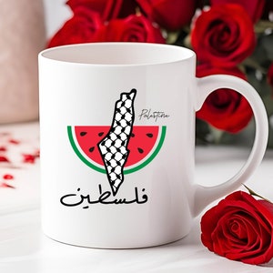 May include: White ceramic mug with a black and white graphic of the outline of Palestine shaped like a watermelon. The text "Palestine" and "فلسطين" are printed on the mug.