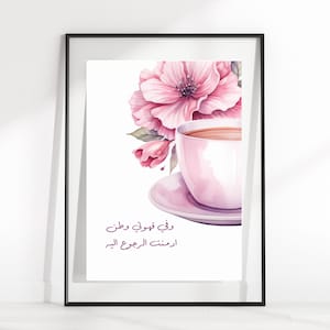 May include: A watercolor painting of a pink teacup and saucer with pink flowers. The text in Arabic reads "I drank the teacup and drank".