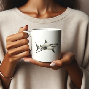 May include: White ceramic mug with a black and white illustration of a shark on the front.