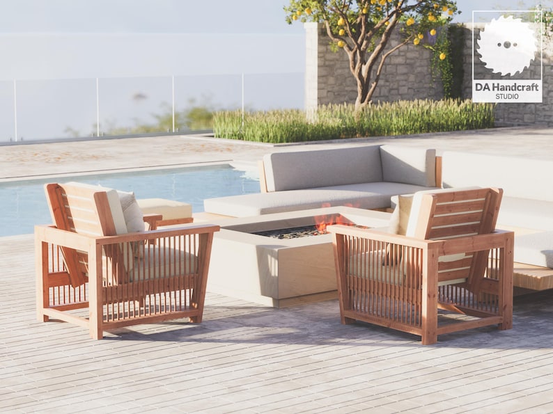 May include: Two wooden chairs with white cushions sit on a wooden deck next to a fire pit and a white sectional sofa. The chairs have a slatted design and are made of natural wood. The fire pit is made of stone and has a fire burning inside. The sofa is made of white fabric and has a modern design.