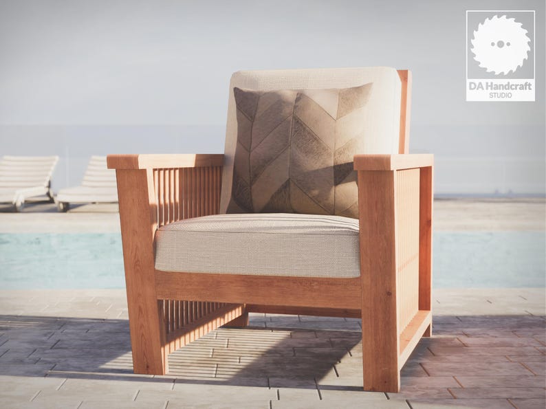 May include: A wooden armchair with a light brown cushion and a patterned pillow. The chair is sitting on a patio near a swimming pool.